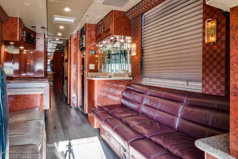 Prevost XLII crew bus lounge with leather sofa and dinette seating area