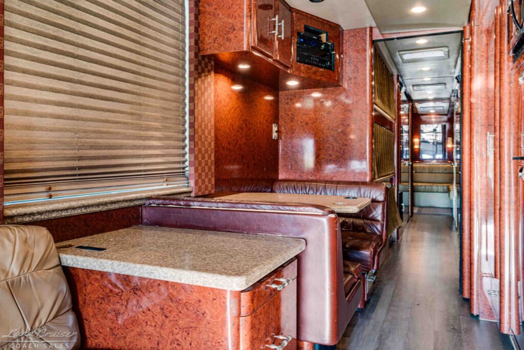 Prevost XLII crew bus front lounge dinette and galley walkway with wood cabinetry