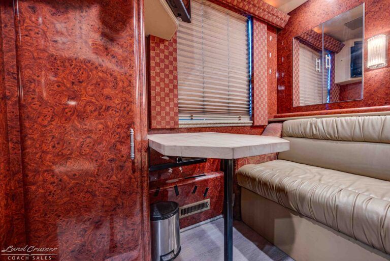 Prevost XLII booth dinette seating with storage and wood panel interior